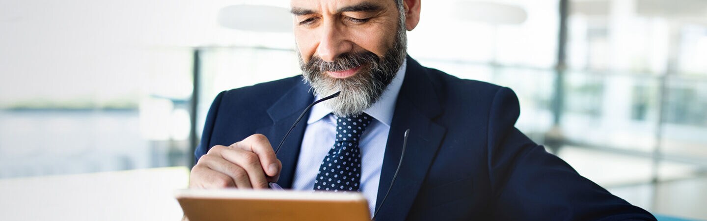 Mann schaut auf sein Tablet.