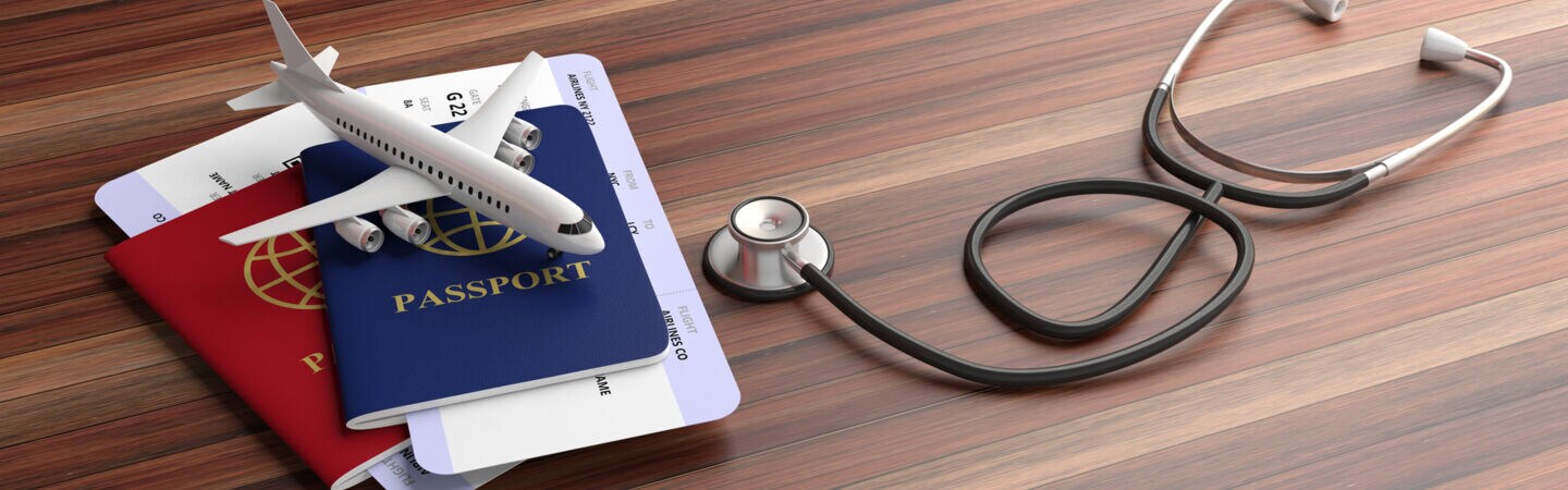 Bild: Stethoskop und reisepass auf dem Tisch
