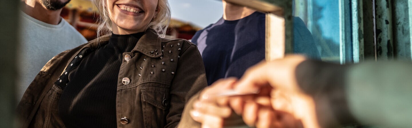 Artikelbild Person erhält ein Ticket am Schalter