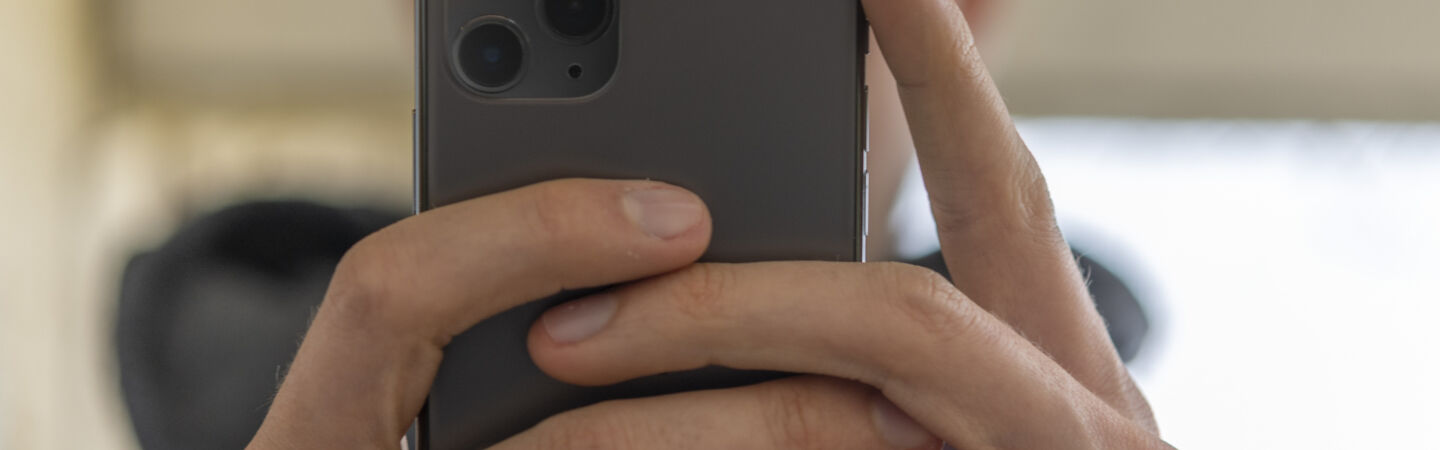 Artikelbild Person hält iPhone 11