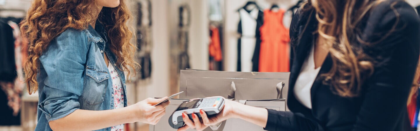Person bezahlt mit ihrer Karte an der Kasse eines Geschäfts