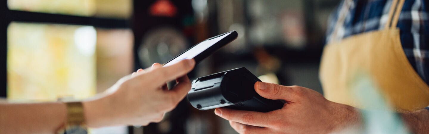 In einem Geschäft witd kontaktlos bezahlt mir dem Handy