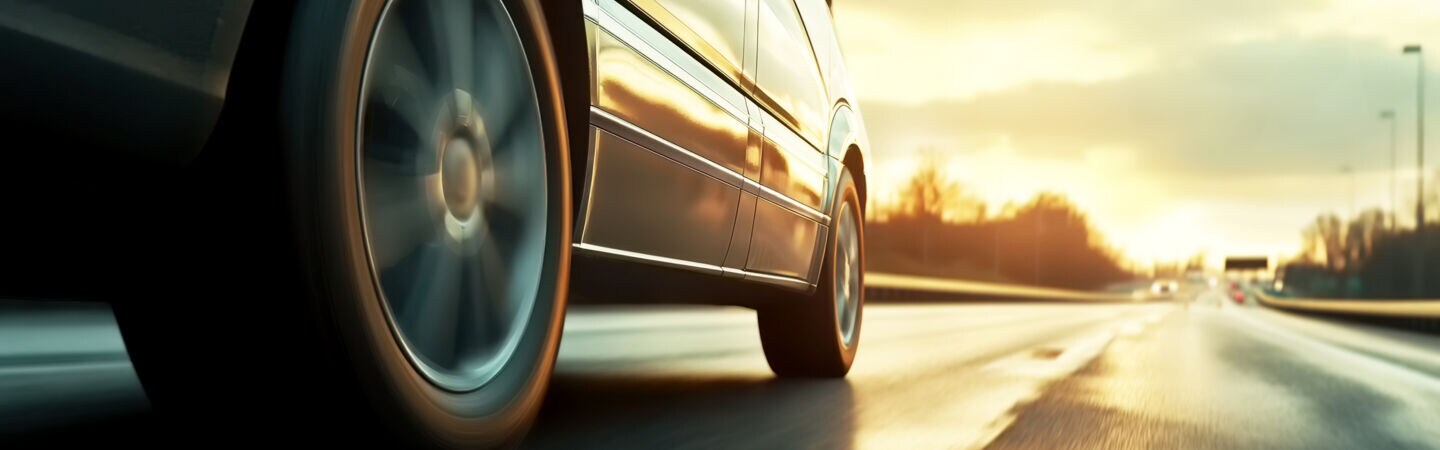 Auto fährt über die Straße bei Sonnenuntergang