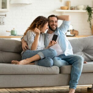 Glückliches Pärchen auf einer grauen Couch