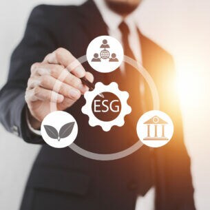 Ein Mann, der mit einem Stift auf ein transparentes ESG-Symbol tippt