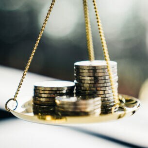 Münzstapel in einer Waagschale