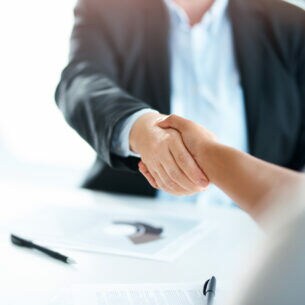 Zwei Menschen schütteln sich die Hände