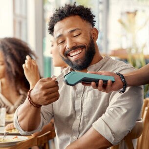 Ein Mann bezahlt in einem Restaurant mit einer Kreditkarte.