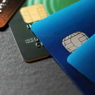 Nahaufnahme von vier unterschiedlich farbigen Kreditkarten, die versetzt übereinander liegen.