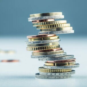 Nahaufnahme aufgetürmter Münzen auf einem Tisch