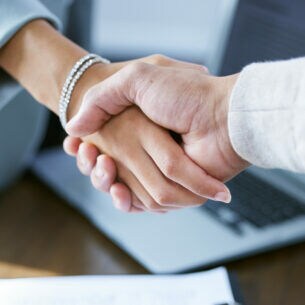 Zwei Personen reichen sich die Hände.