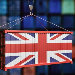 Ein von einem Kran getragener Container, dessen eine Seite die Flagge Großbritanniens darstellt.