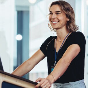 Lächelnde Frau mit Headset hält eine Präsentation