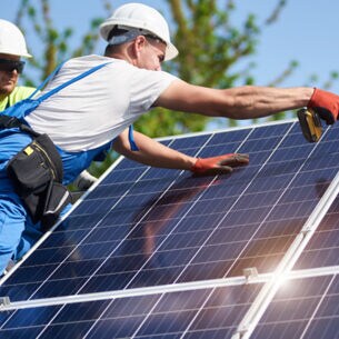 zwei Männer arbeiten an einer Solaranlage
