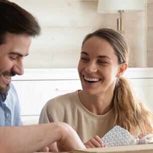 glueckliches-junges-paar-packt-online-bestellung-aus