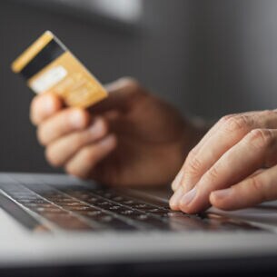 Nahaufnahme von Kreditkarte und Laptop während des Online-Shoppings