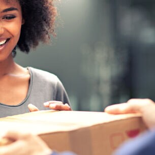 Frau enthält lächelnd ein Paket