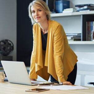 Eine Frau steht an ihren Schreibtisch.