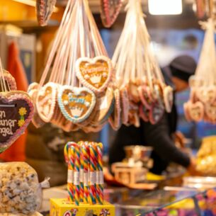 Die Aufschrift "Mein kleiner Engel" ist auf einem Lebkuchenherz zu lesen, im Hintergrund packt ein Verkäufer eine Tüte mit Süßigkeiten. Das Bayreuther Winterdorf verbreitet bereits vor dem Aufbau des offiziellen Weihnachtsmarktes weihnachtliche Stimmung. (zu dpa: «Alkohol, Süßes und Fleisch: Ladenhüter nach dem Fest»)