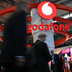 Menschen gehen auf der Mobilfunk-Messe Mobile World Congress (MWC) am Stand des Telekommunikationskonzerns Vodafone vorbei. (zu dpa: «Vodafone startet Sicherheitsnetz
