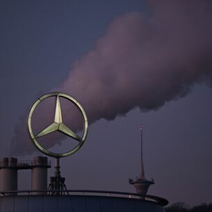 Der Mercedes Stern, das Logo des Fahrzeugherstellers Mercedes-Benz steht auf einem Gebäude einer Niederlassung, dahinter steigt eine Wolke aus einem Schornstein auf. Zuletzt häuften sich bei Mercedes die Negativschlagzeilen. Bei dem Autobauer gibt es mehrere Baustellen. (zu dpa: «Mercedes: Prämie für Beschäftigte niedriger als in Vorjahren»)