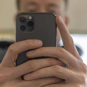 Artikelbild Person hält iPhone 11