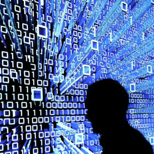 Ein Messebesucher geht an einem Leuchtdisplay auf der CeBIT vorbei. (zu dpa: «Bitkom und SAP: KI ist Chance, kein Job-Killer»)