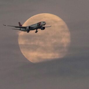 Ein Flugzeug der TAP Air Portugal nähert sich vor Sonnenaufgang dem Flughafen von Lissabon, während der Mond noch am Himmel steht. (zu dpa: «EU-Verkehrsminister stimmen über neue Fluggastrechte ab»)