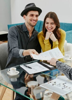 Ein glückliches Paar übergibt ein Dokument einer Frau