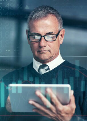 Mann in Hemd und Krawatte, der auf ein Tablet blickt