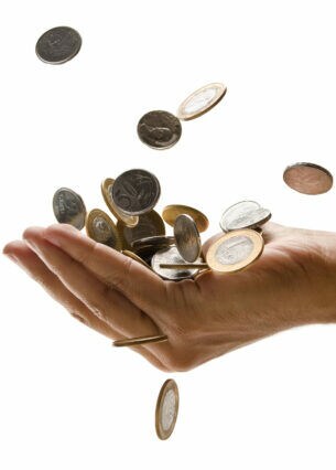 In eine Hand und darunter fallende Münzen