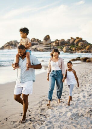 Eine Familie geht gemeinsam am Strand spazieren.