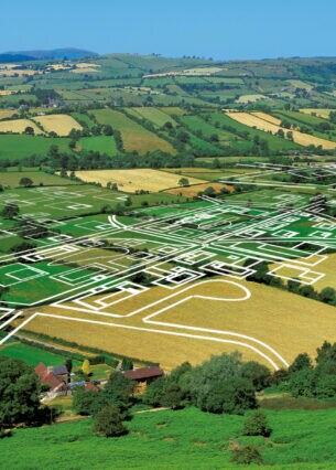 Grundstückspläne sind über eine grüne Feldlandschaft gezeichnet