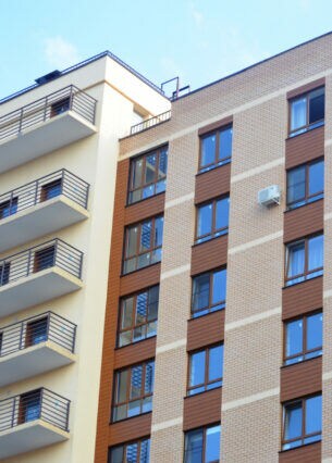 Eine Fassade eines mehrstöckigen Hauses mit Balkonen.