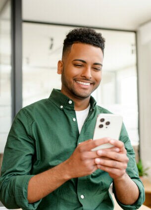 Eine Person sitzt mit einem iPhone in einem Büroumfeld.