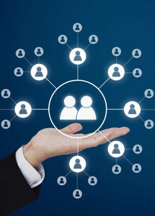 Um eine nach oben hin geöffnete Hand schweben weiße Kreise, die miteinander verbundene Personen darstellen.