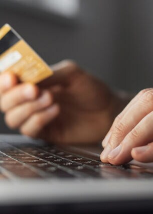 Nahaufnahme von Kreditkarte und Laptop während des Online-Shoppings