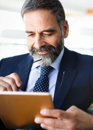 Mann schaut auf sein Tablet.