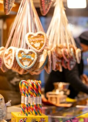 Die Aufschrift "Mein kleiner Engel" ist auf einem Lebkuchenherz zu lesen, im Hintergrund packt ein Verkäufer eine Tüte mit Süßigkeiten. Das Bayreuther Winterdorf verbreitet bereits vor dem Aufbau des offiziellen Weihnachtsmarktes weihnachtliche Stimmung. (zu dpa: «Alkohol, Süßes und Fleisch: Ladenhüter nach dem Fest»)