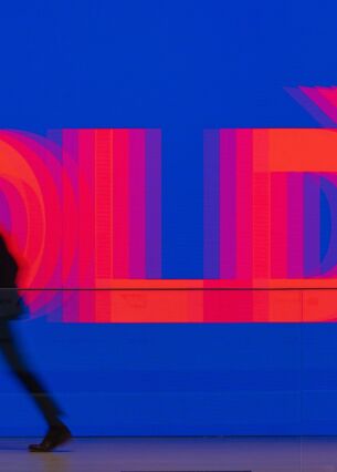 Ein Besucher der Konferenz «Digital Life Design» (DLD) geht am Logo «DLD» vorbei. Auf der Konferenz wird über Internet-Trends und Entwicklungen der Digitalisierung diskutiert. (zu dpa: «Experte: Stehen erst am Beginn der KI-Entwicklung»)