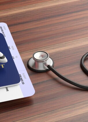Bild: Stethoskop und reisepass auf dem Tisch
