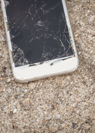 Artikelbild: Zerbrochenes Display eines Handys auf dem Boden