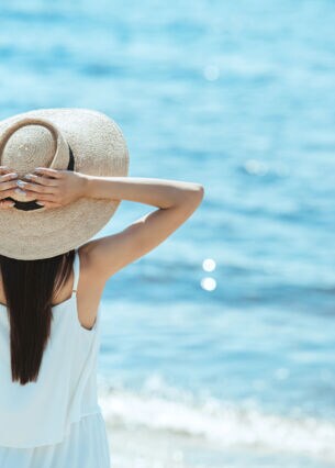 Artikelbild: Frau mit Hut am Strand