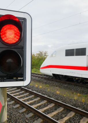 Eine rote Ampel leuchtet an einem Bahnübergang, ein ICE der Deutschen Bahn fährt vorbei. Die Strecke zwischen Mannheim und Stuttgart wird ab dem 17. April gesperrt. (zu dpa: «Bahnstrecke Mannheim-Stuttgart von Ostern an gesperrt»)