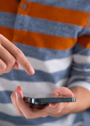 Artikelbild Person zeigt auf sein iPhone