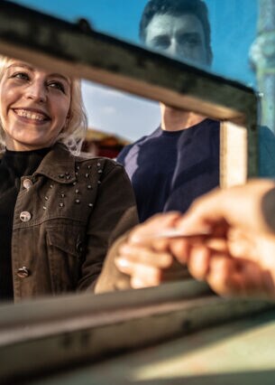 Artikelbild Person erhält ein Ticket am Schalter