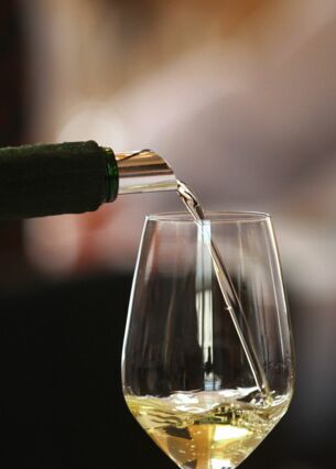 Ein Glas wird mit Weißwein gefüllt. (zu dpa: «Spitzenweine werden häufiger direkt beim Winzer gekauft»