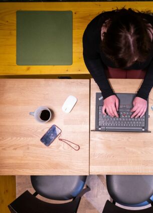 Eine Frau sitzt im Homeoffice am Küchentisch und arbeitet an einem Laptop (gestellte Szene). (zu dpa: «Umfrage: Zwei Drittel arbeiten auch mal krank im Homeoffice»)