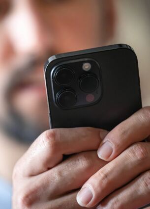 Ein Mann schaut auf ein Smartphone. Das Berliner Start-up Parloa, ein Spezialist für automatisierte Kundengespräche, wird nach einer dritten großen Finanzierungsrunde mit über einer Milliarde Dollar bewertet. (Symbolbild) (zu dpa: «Berliner KI-Start-up Parloa erzielt Milliarden-Bewertung»)