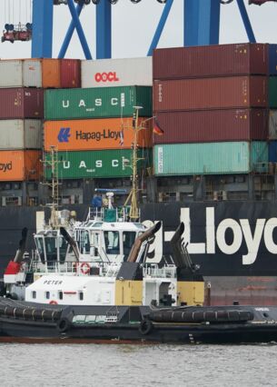 Der Schlepper „Peter“ fährt neben einem Containerschiff der Reederei Hapag-Lloyd am Container Terminal Altenwerder (CTA) vorbei. (zu dpa: «ZEW: Konjunkturerwartungen besser als erwartet»)